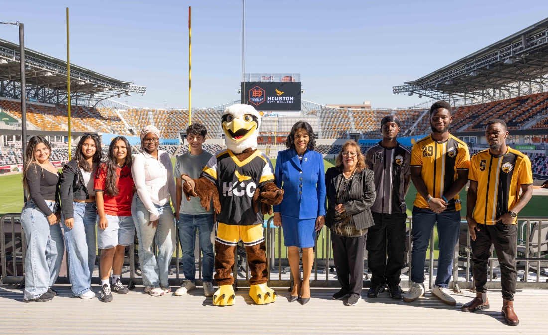 HCC students, the mascot Swoop and HCC officials pose for a photo Shell Energy Stadium.