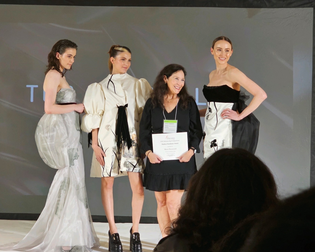 Maria Hammond, with certificate, poses with models wearing her gowns at the event in Dallas