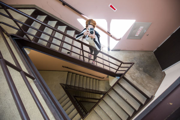 Female photography student taking a photo in a stairwell