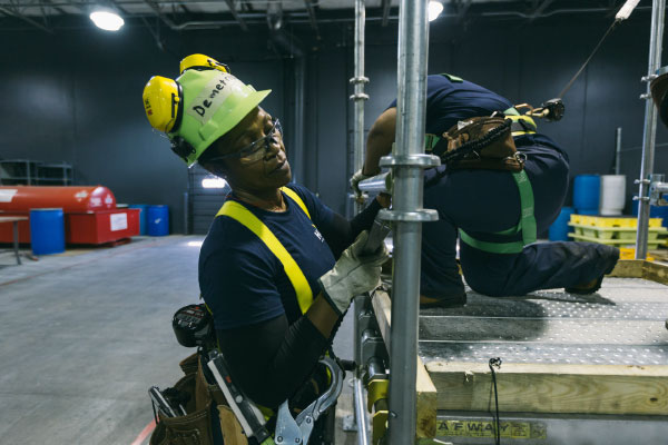 Female construction student fitting some pipes