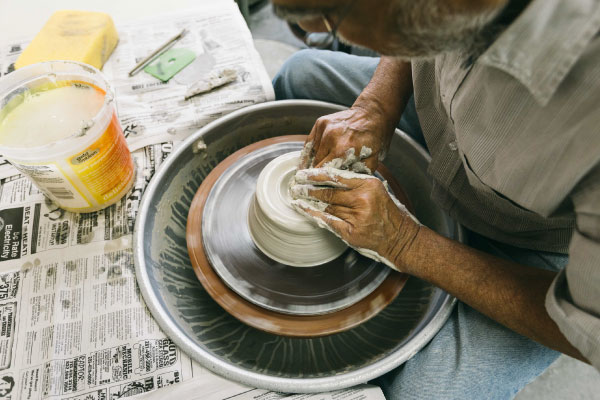 Art student scuplting some clay on a sculpting wheel